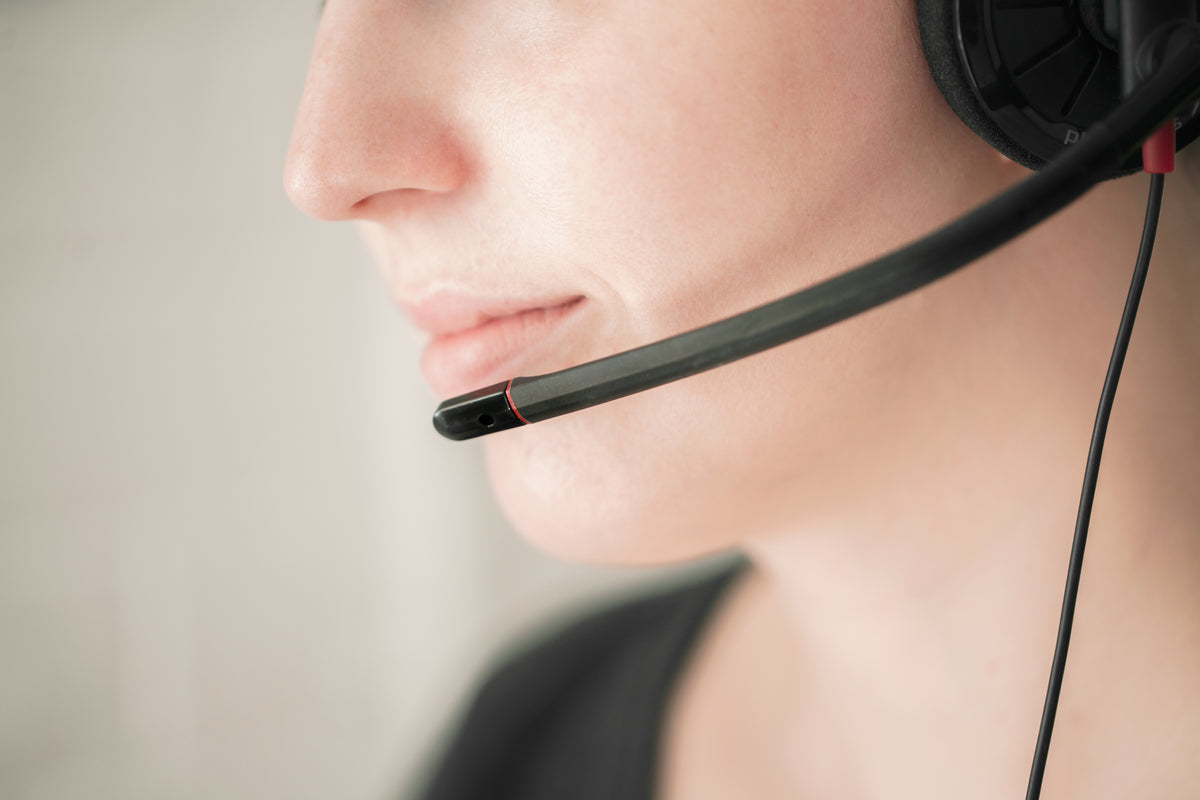 Close-up of a support agent wearing a headset microphone