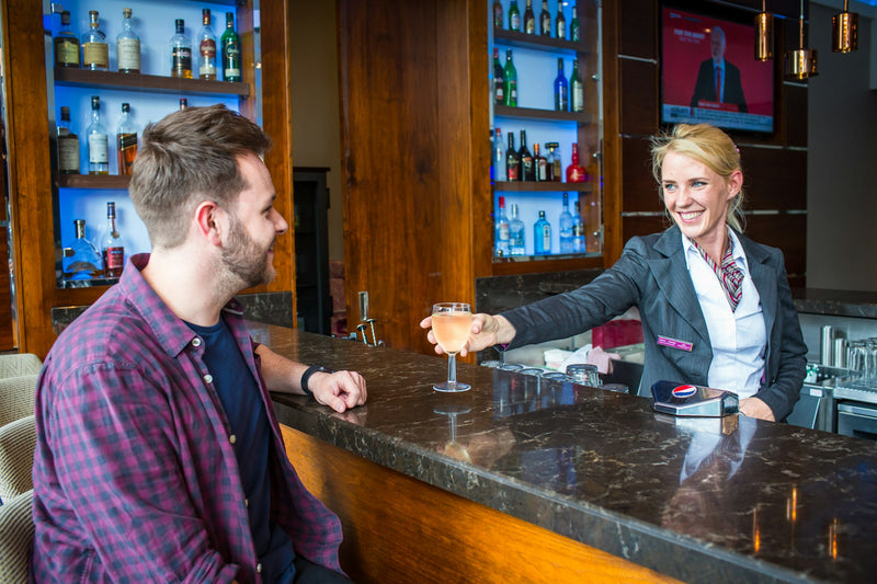 Bartender serving a guest at a hotel bar