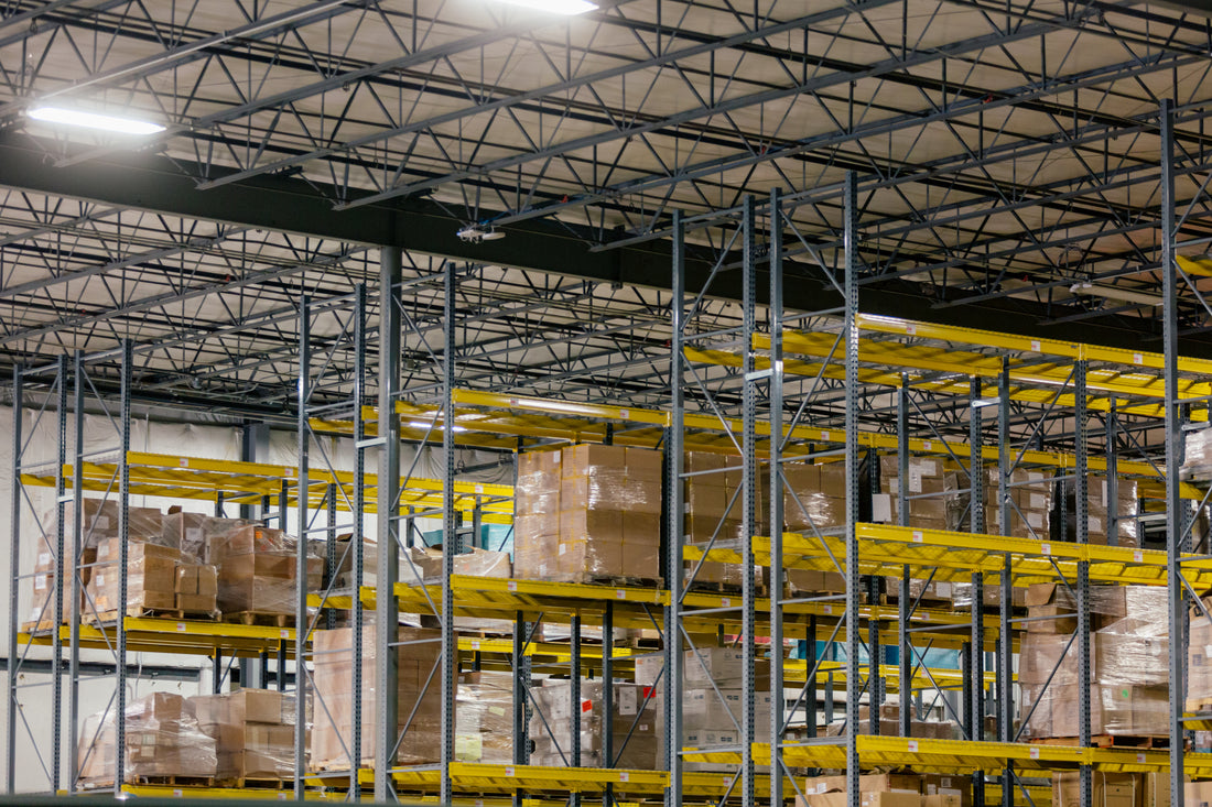 Warehouse pallet racking loaded with boxed inventory under high steel ceiling trusses