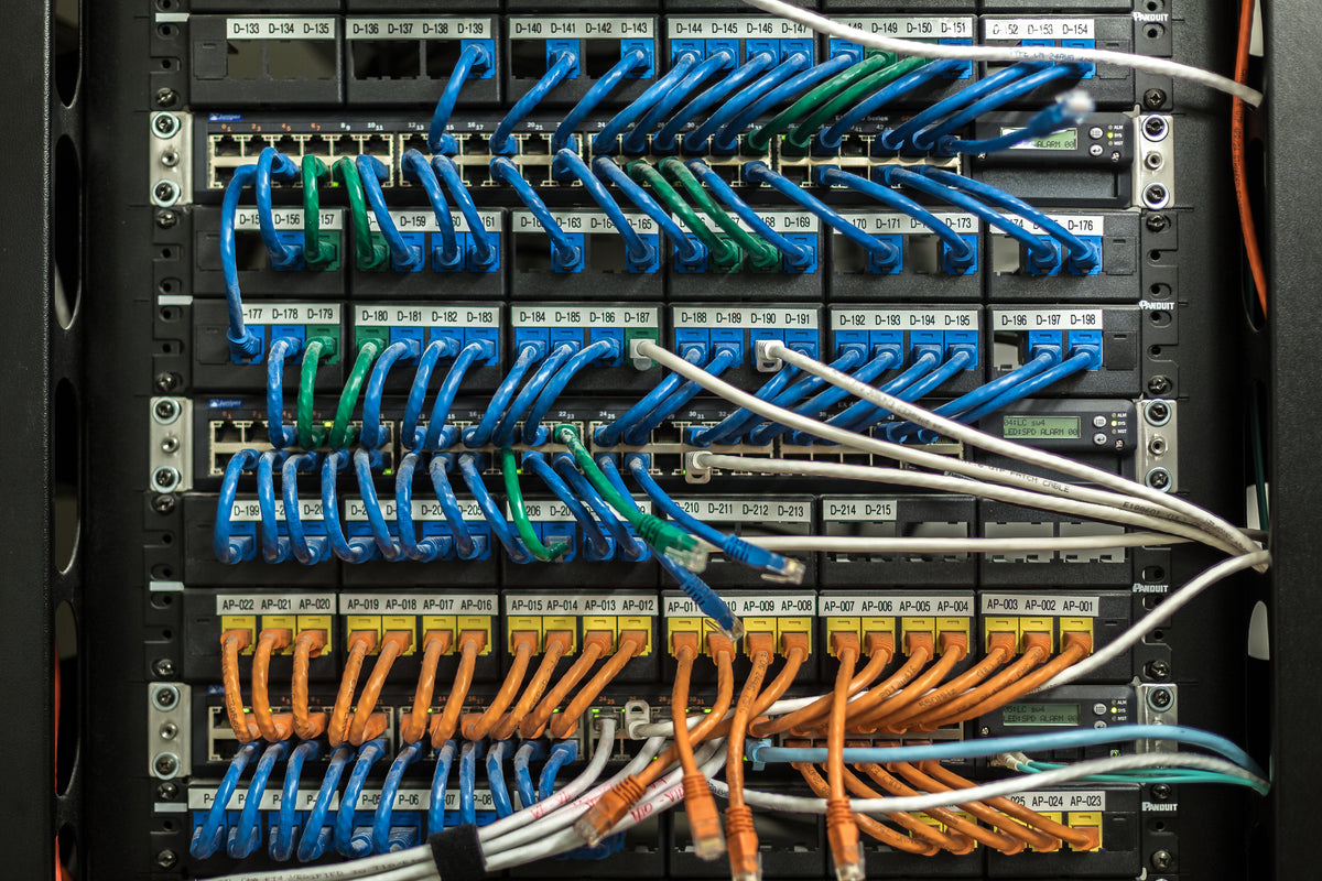 Server rack with color-coded blue, green, and orange patch cables neatly organized