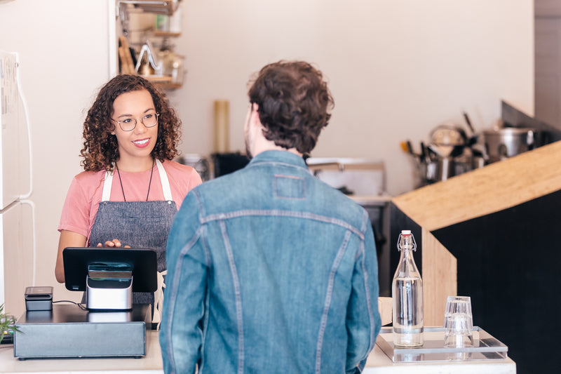 Barista serving a coffee shop customer